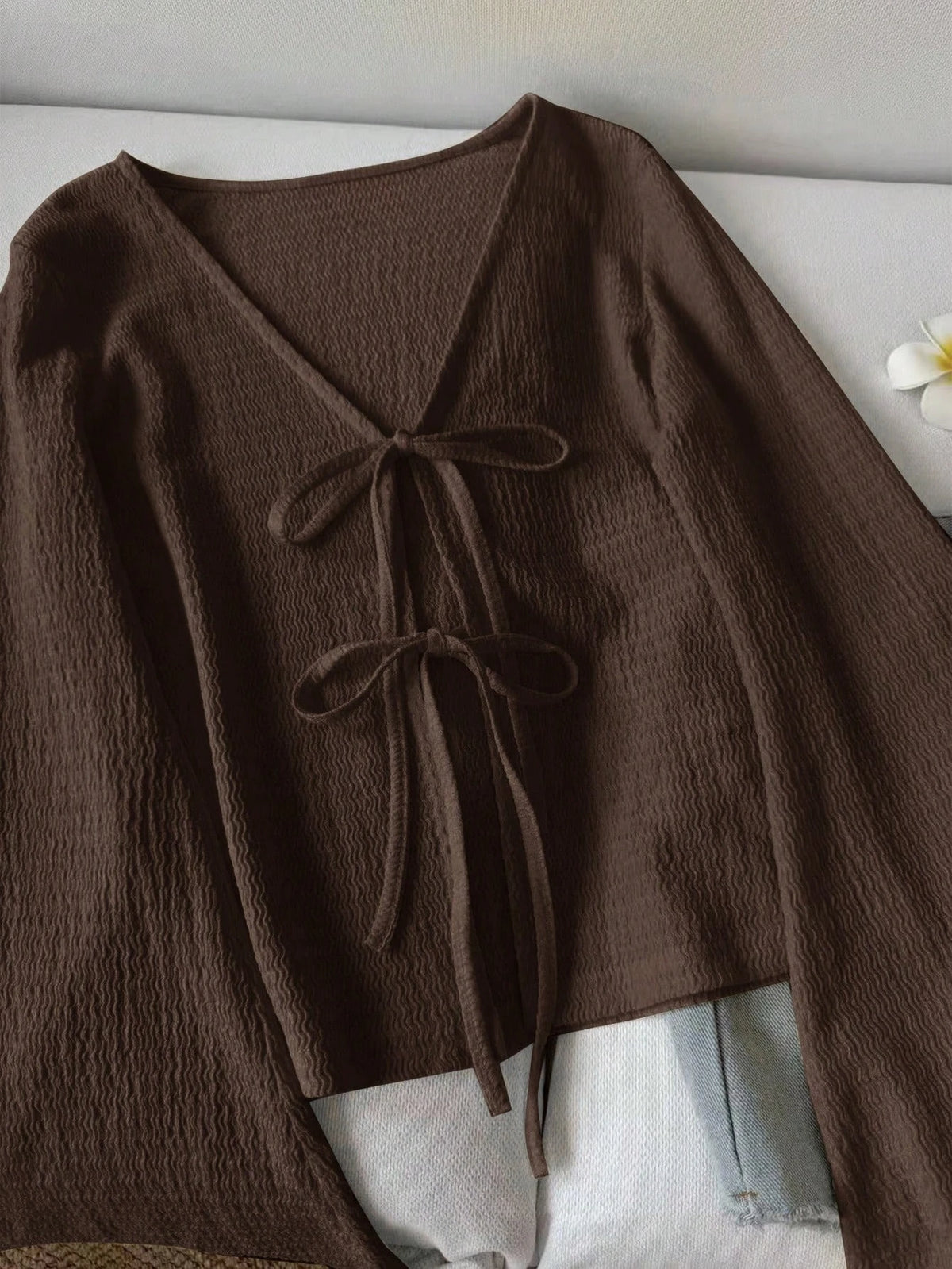 Blusa de punto con lazo frontal y mangas acampanadas