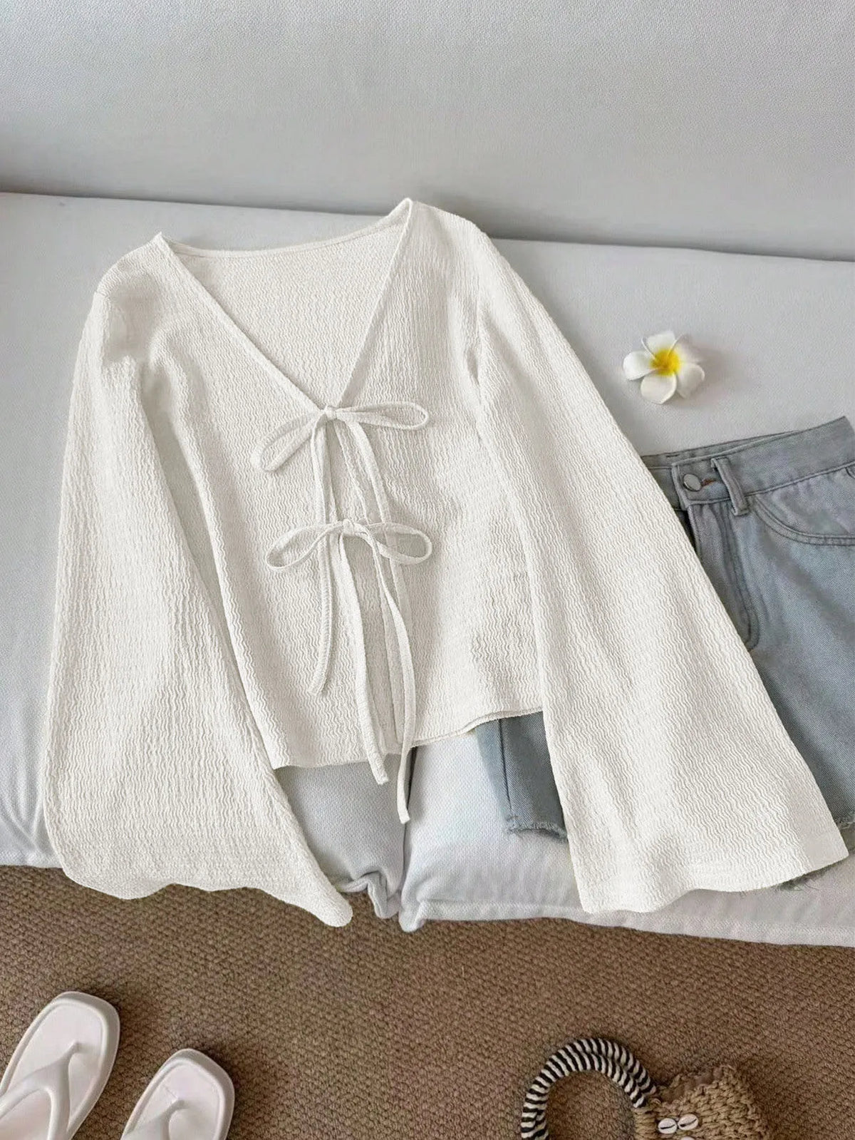 Blusa de punto con lazo frontal y mangas acampanadas