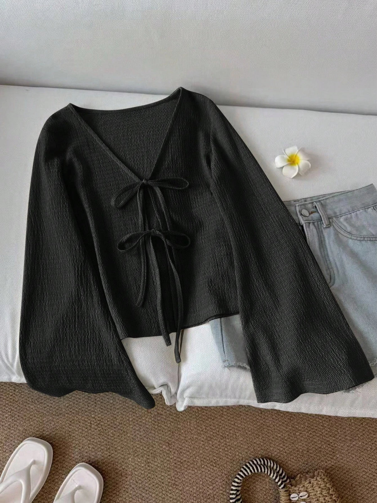 Blusa de punto con lazo frontal y mangas acampanadas