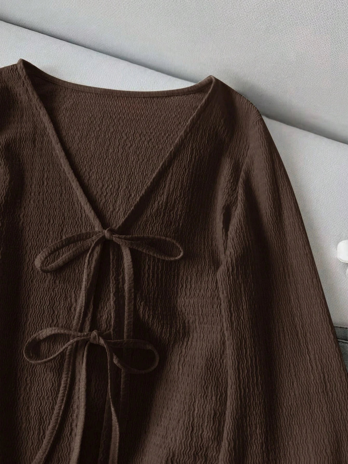 Blusa de punto con lazo frontal y mangas acampanadas