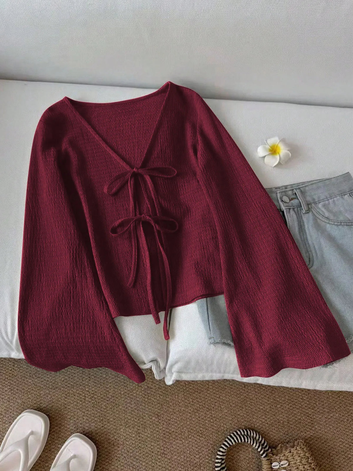 Blusa de punto con lazo frontal y mangas acampanadas