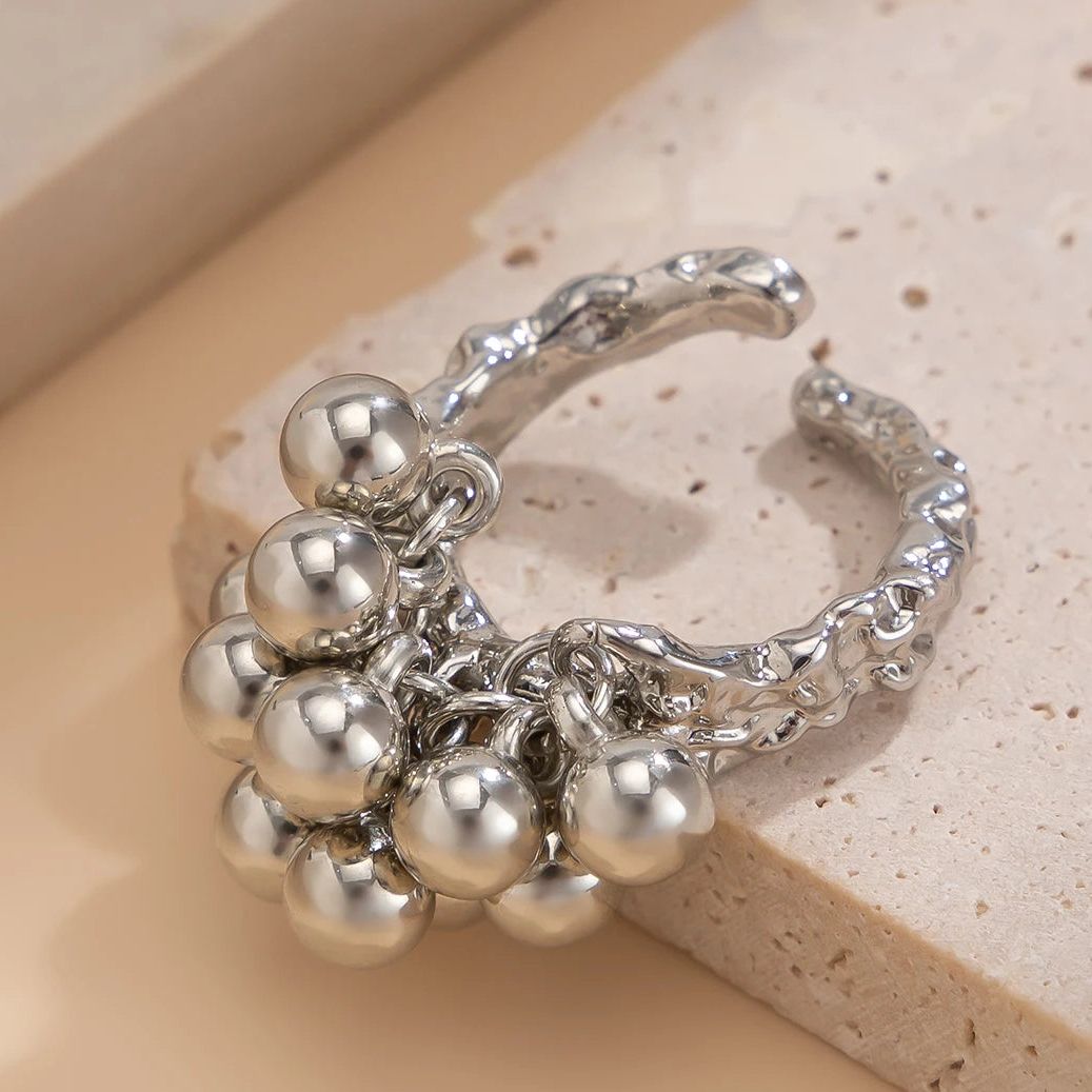 Anillo geométrico abierto con detalle de esfera