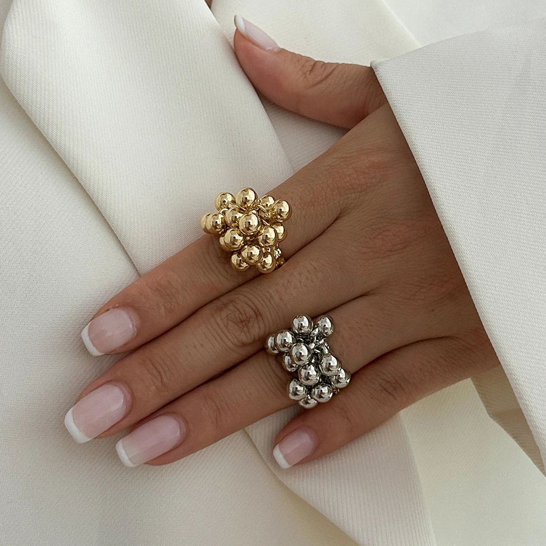 Anillo geométrico abierto con detalle de esfera